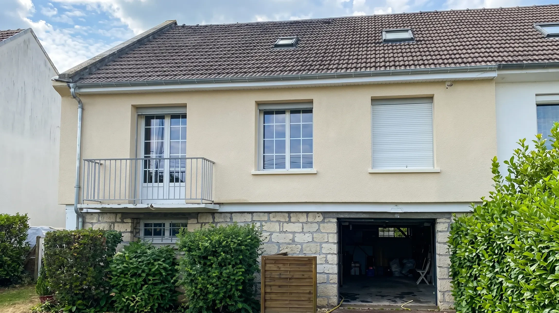 Scène extérieure montrant une personne tenant un panneau de contreplaqué ou OSB devant une façade de chalet en bois
