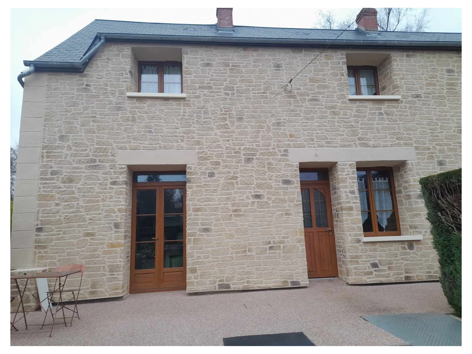 Chantier de construction résidentielle en cours avec ouvriers travaillant sur une maison à deux niveaux